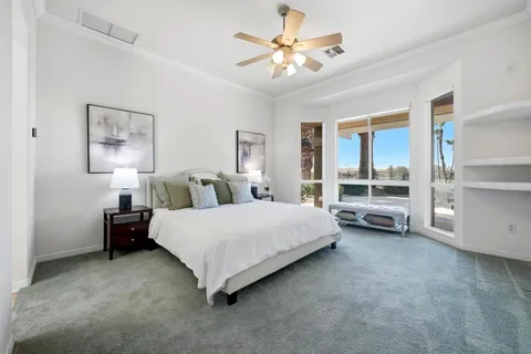 a spacious bedroom with a bed and a chandelier
