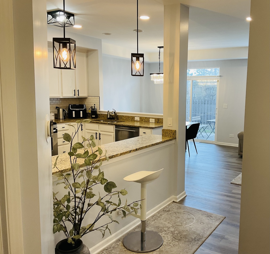 2425 Birch Street Des Plaines, IL 60018 - Photo 7 of 40 a kitchen view with granite countertop a stove a sink and a chandelier