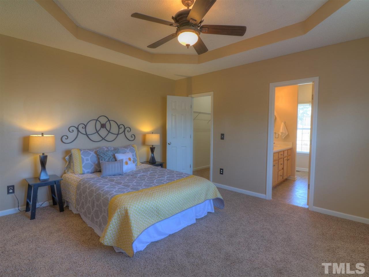 8505 Rockcliff Road Raleigh, NC 27603 - Photo 8 of 25 a bedroom with a bed and a chandelier