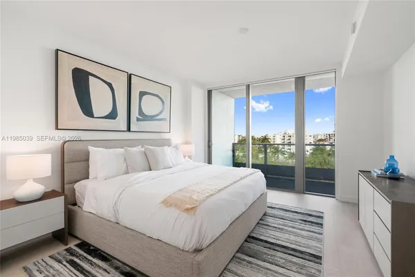 a bedroom with a bed window and mirror
