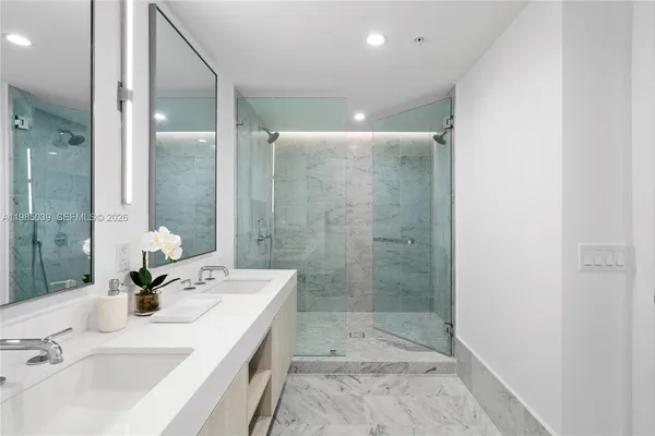 a bathroom with a double vanity sink mirror and shower