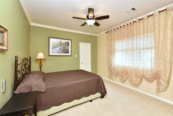 a bedroom with a large bed and a chandelier