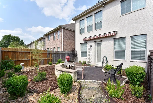 a backyard of a house with table and chairs