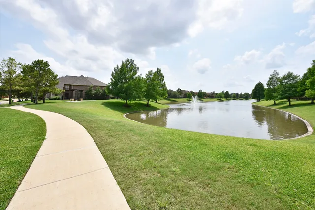 a view of a lake with a big yard and large trees