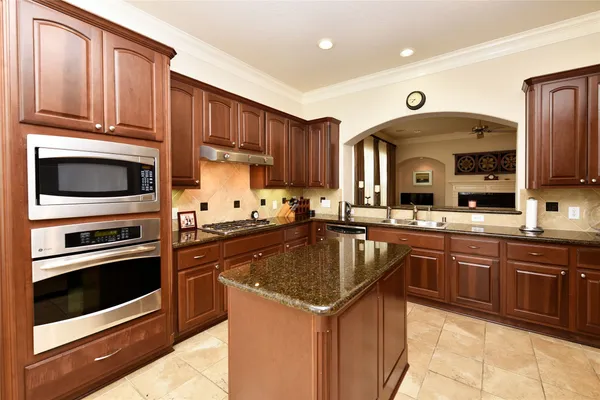 a kitchen with granite countertop a stove sink and microwave