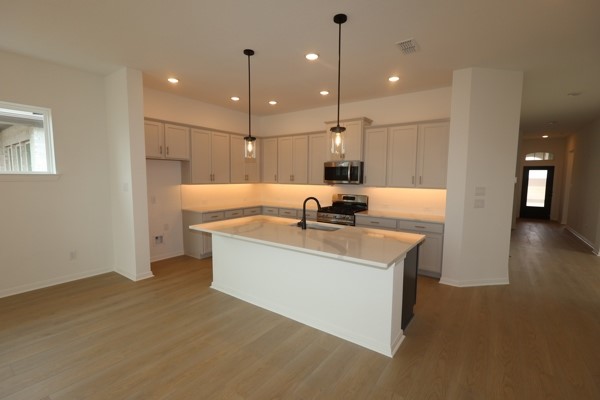 322 Big Pne Trail Rosenberg, TX 77471 - Photo 4 of 14 a view of a room with kitchen island stainless steel appliances wooden floor and living room view