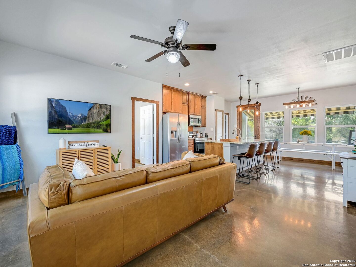 6766 Spring Branch Road Spring Branch, TX 78070 - Photo 5 of 63 a living room with couches a flat screen tv and kitchen view