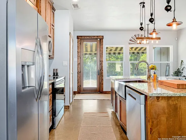 a kitchen with stainless steel appliances granite countertop a refrigerator and a sink
