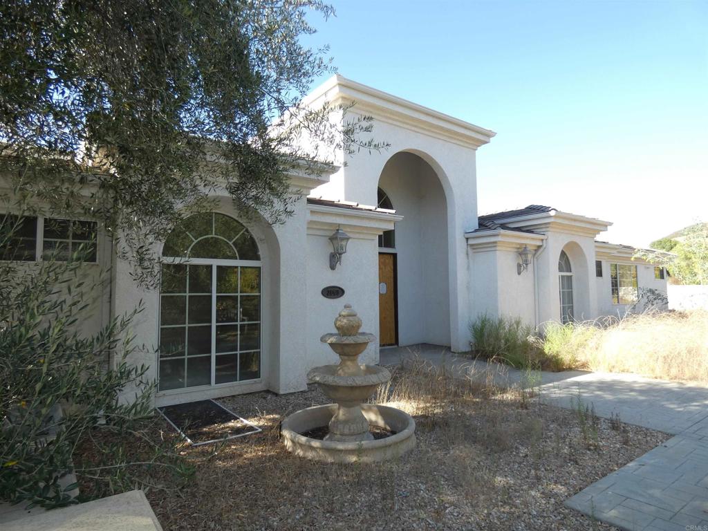 a view of a house with a yard and large tree