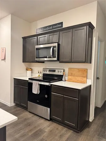a kitchen with stainless steel appliances a sink a stove a refrigerator and cabinets