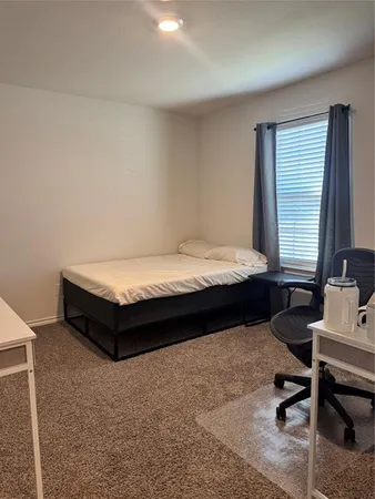 a bedroom with a bed and a desk