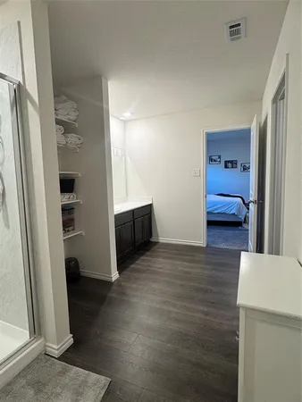 a spacious bedroom with a bed and painting on the wall