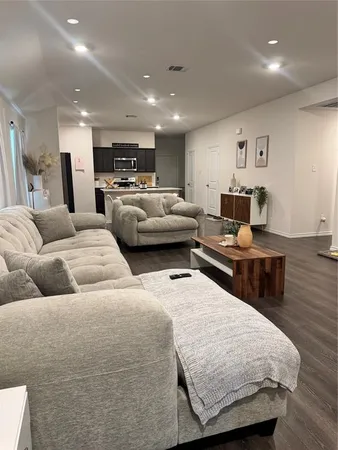 a living room with furniture and kitchen view