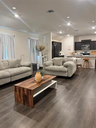a living room with furniture and view of kitchen