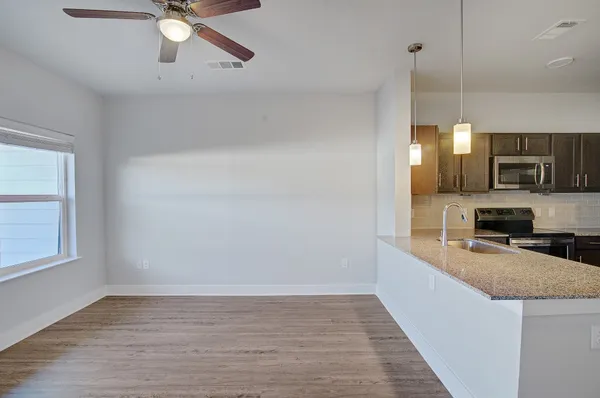 a kitchen with granite countertop a stove a sink and a microwave