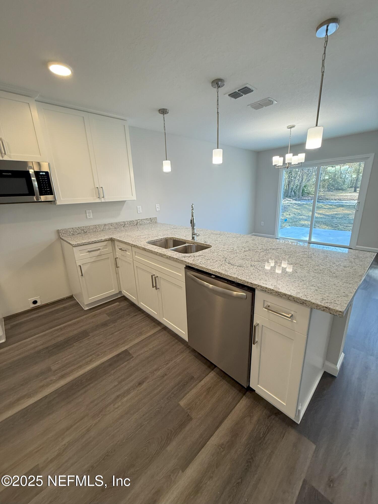 8822 Orme Road Jacksonville, FL 32220 - Photo 17 of 26 a kitchen with a sink cabinets and wooden floor