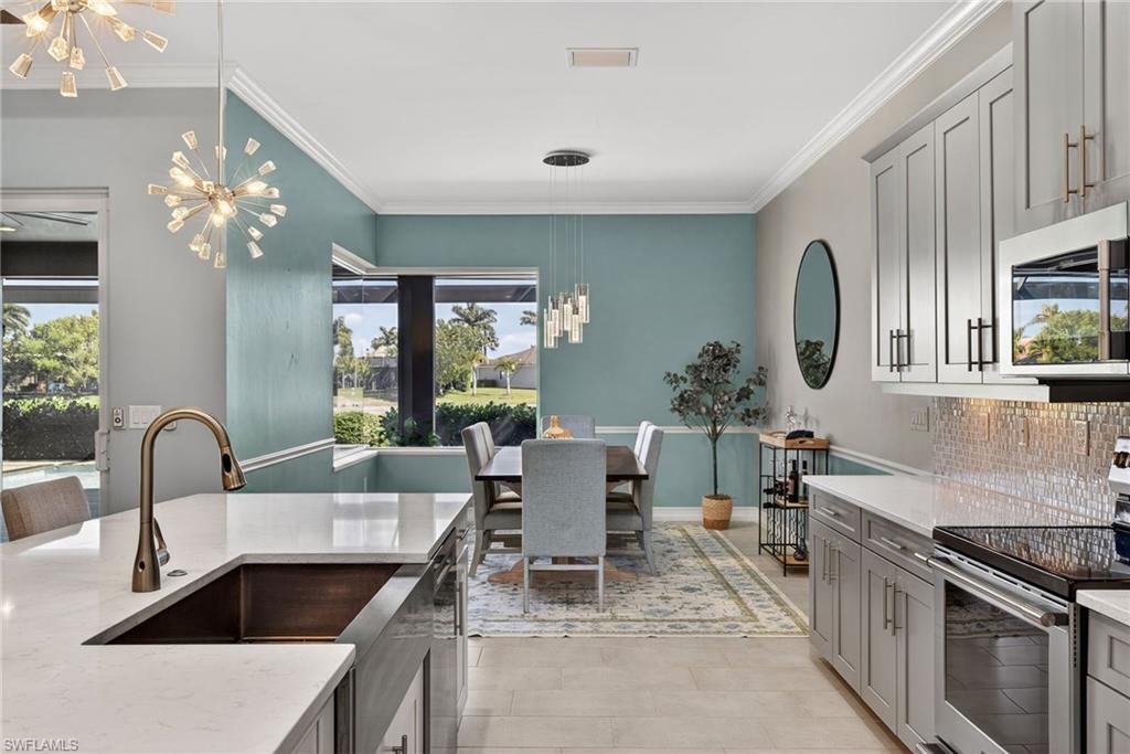 14748 Windward Lane Naples, FL 34114 - Photo 14 of 50 a kitchen with a table chairs and stove
