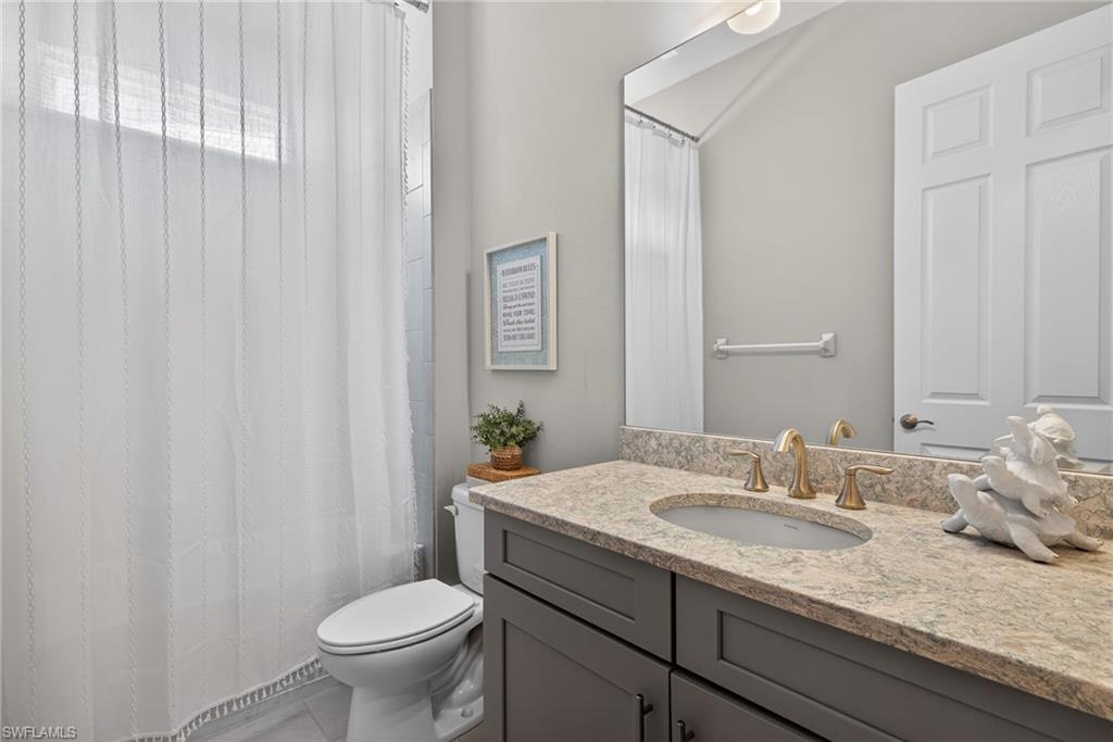 14748 Windward Lane Naples, FL 34114 - Photo 20 of 50 a bathroom with a granite countertop sink and a toilet