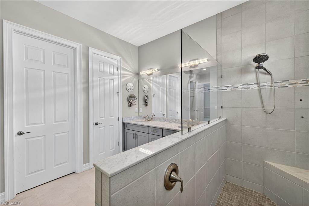 14748 Windward Lane Naples, FL 34114 - Photo 26 of 50 a bathroom with a granite countertop sink a toilet and shower