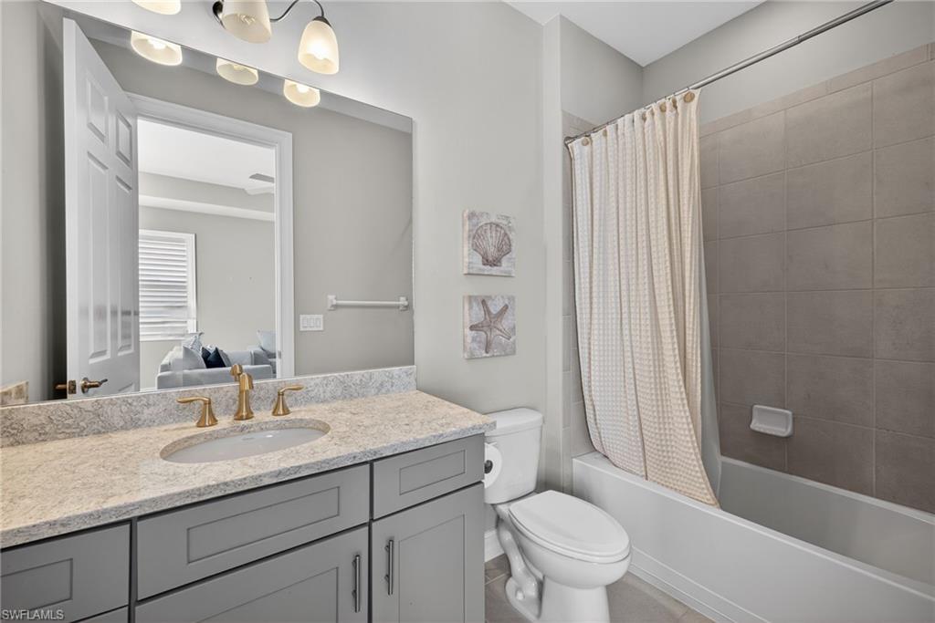 14748 Windward Lane Naples, FL 34114 - Photo 35 of 50 a bathroom with a granite countertop sink a toilet and a large mirror