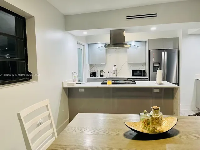 a kitchen with a sink appliances and a living room