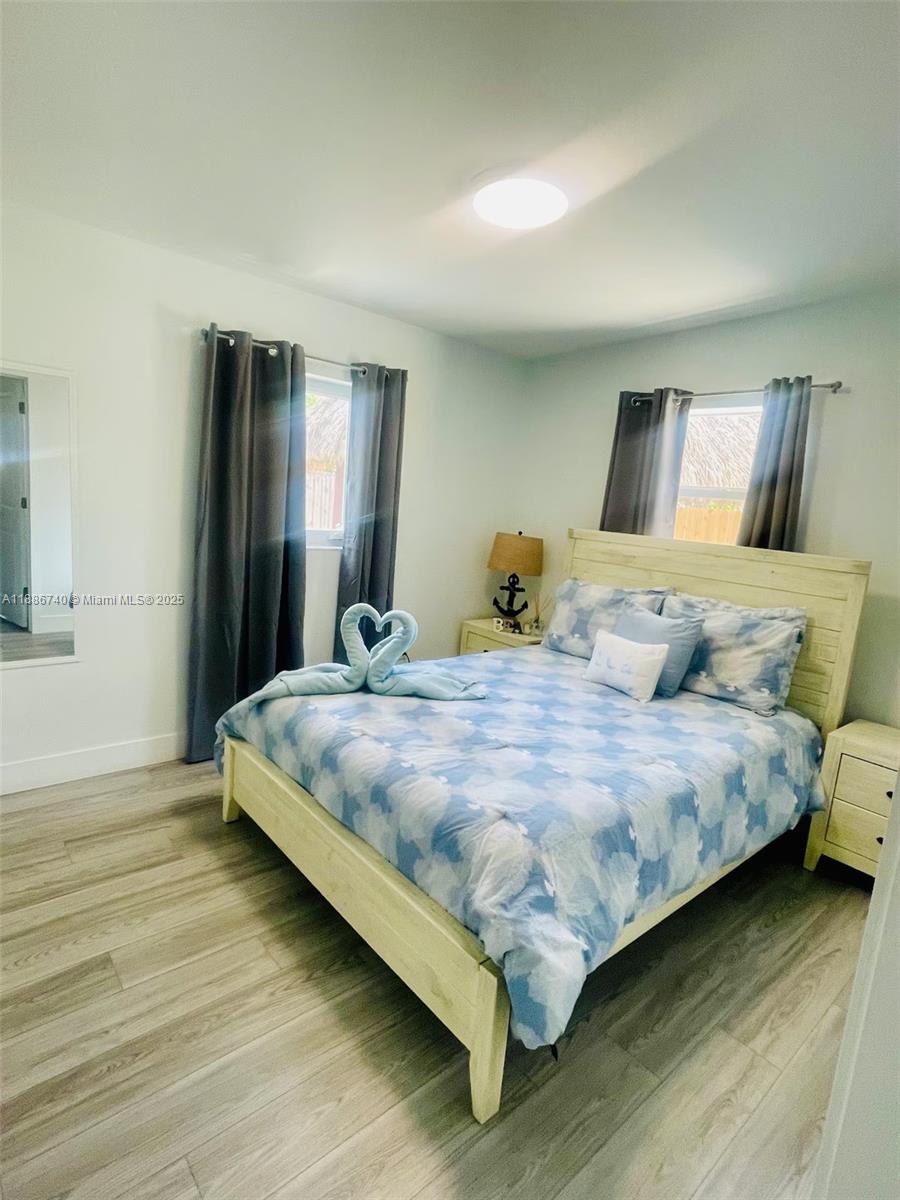 237 2nd Road Key Largo, FL 33037 - Photo 8 of 11 a bedroom with a bed and wooden floor