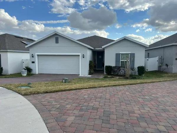 a view of a house with a yard and a large tree