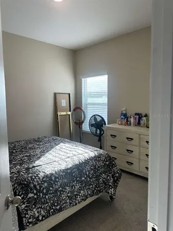 a bed sitting in a bedroom next to a window