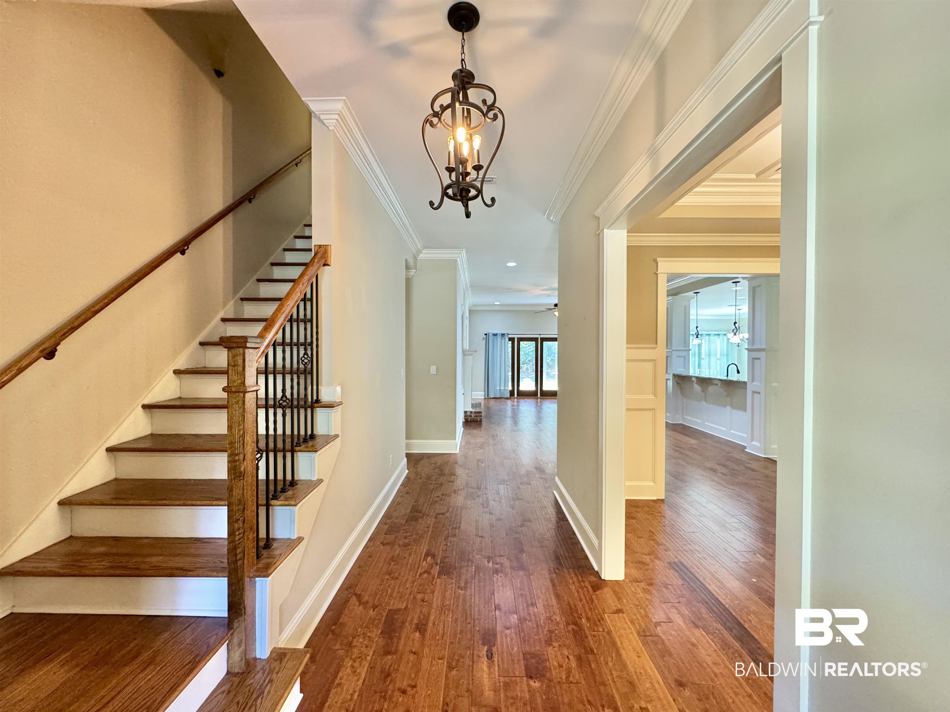 10846 County Road 138 Bay Minette, AL 36507 - Photo 17 of 53 Stairs with crown molding, hardwood / wood-style flooring, and ceiling fan with notable chandelier