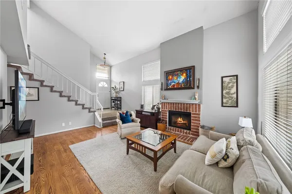 a living room with furniture fireplace and wooden floor