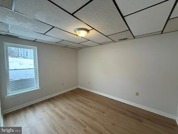 a view of a room with wooden floor and windows