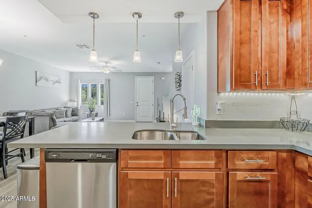 a view of a kitchen with kitchen island a sink stainless steel appliances wooden floor and a counter top space