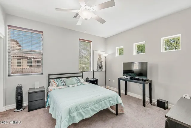 a spacious bedroom with a bed and a chandelier