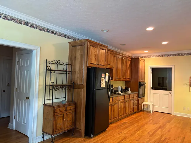 a kitchen with stainless steel appliances kitchen island granite countertop a refrigerator and a stove top oven