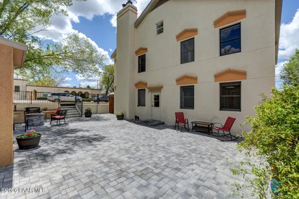 a backyard of a house with fire pit and outdoor seating