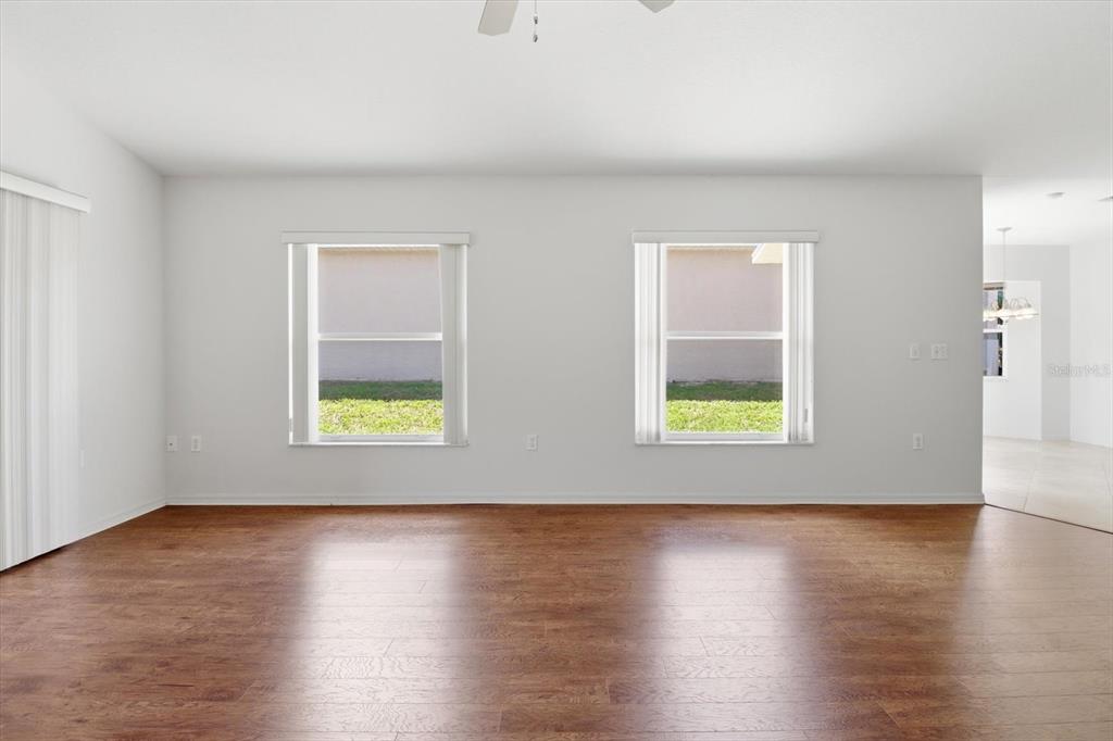 826 West Cockatiel Loop Hernando, FL 34442 - Photo 6 of 40 a view of an empty room with wooden floor and a window