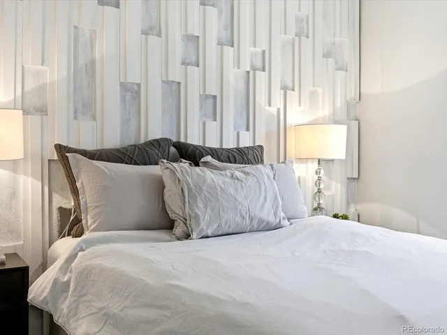 a large bed sitting in a bedroom next to a window