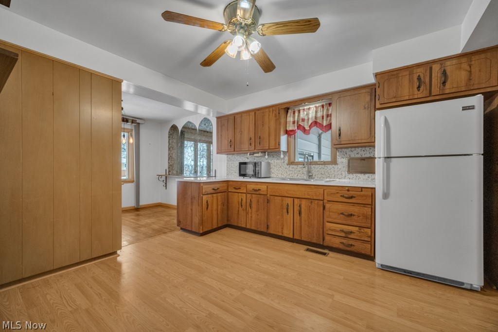 6846 Revere Road Cleveland, OH 44130 - Photo 11 of 30 Kitchen with freestanding refrigerator, light countertops, ceiling fan, wood finish cabinets, and light wood-style flooring