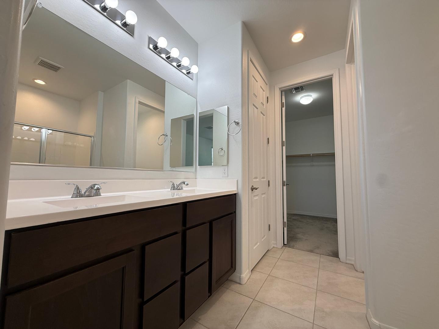 15744 West Jefferson Street Goodyear, AZ 85338 - Photo 18 of 26 a bathroom with a double vanity sink and a mirror