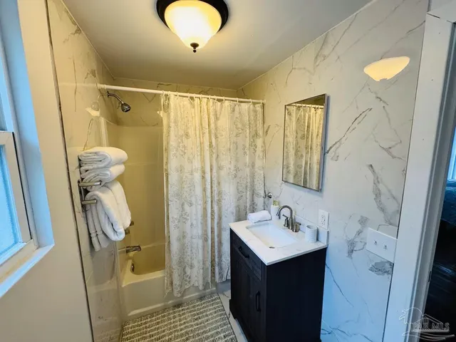 a bathroom with a sink a mirror and shower