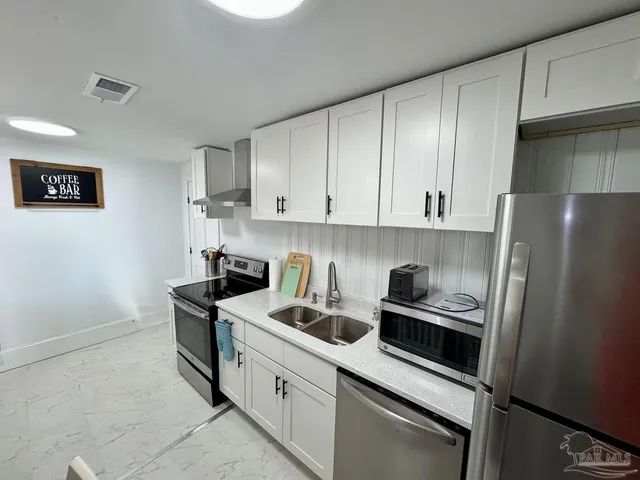 a kitchen with stainless steel appliances a refrigerator sink and stove