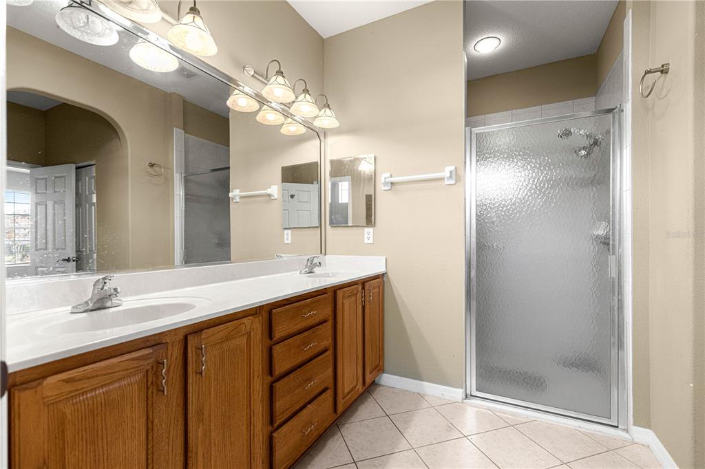 8536 Southwest 82nd Terrace Ocala, FL 34481 - Photo 17 of 47 a bathroom with a double vanity sink mirror and shower
