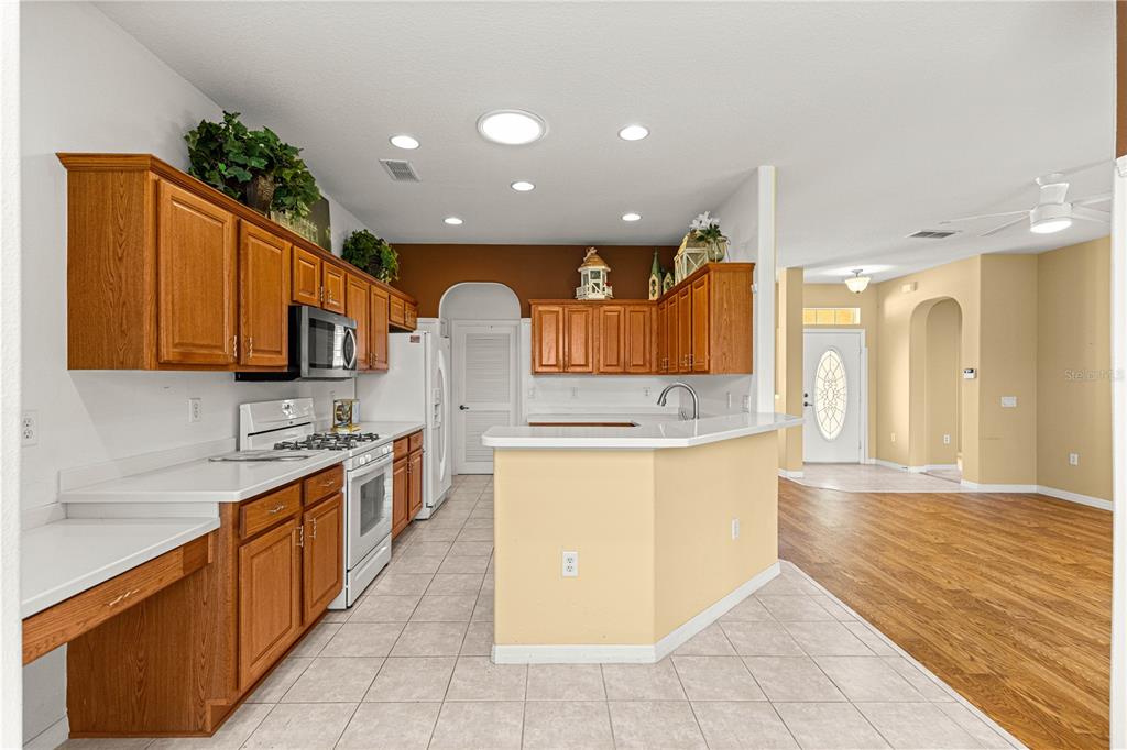 8536 Southwest 82nd Terrace Ocala, FL 34481 - Photo 9 of 47 a large kitchen with stainless steel appliances kitchen island granite countertop a large counter top and wooden cabinets