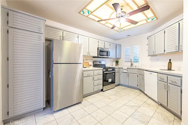a kitchen with granite countertop cabinets stainless steel appliances and a sink