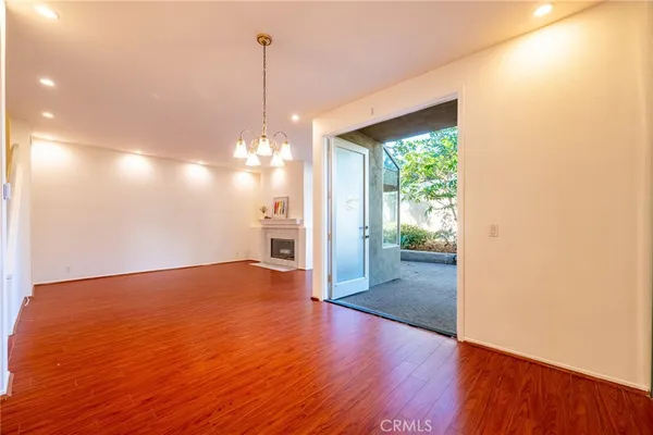 a view of a room with wooden floor a fireplace and window