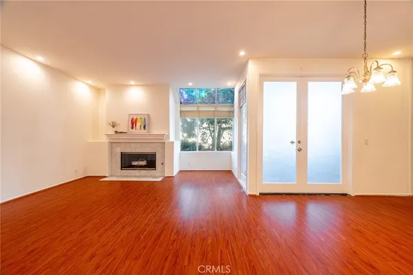 a view of empty room with wooden floor and windows
