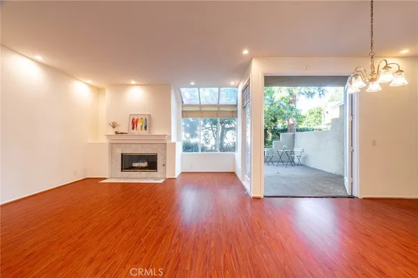 a view of a livingroom with a chandelier fan and wooden floor