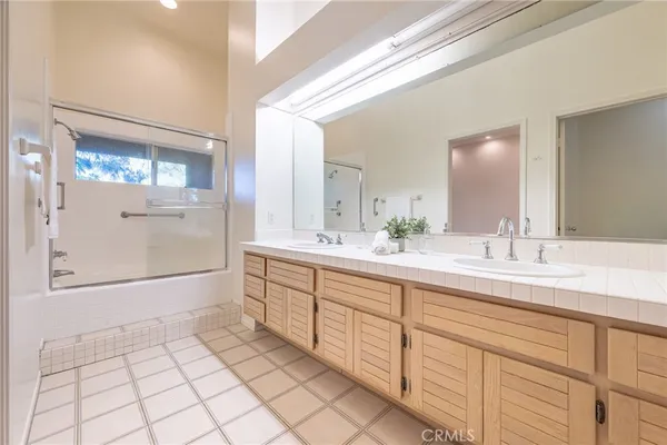 a spacious bathroom with a double vanity sink and a mirror