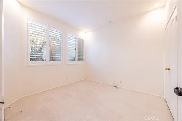 an empty room with a mirror and a shower