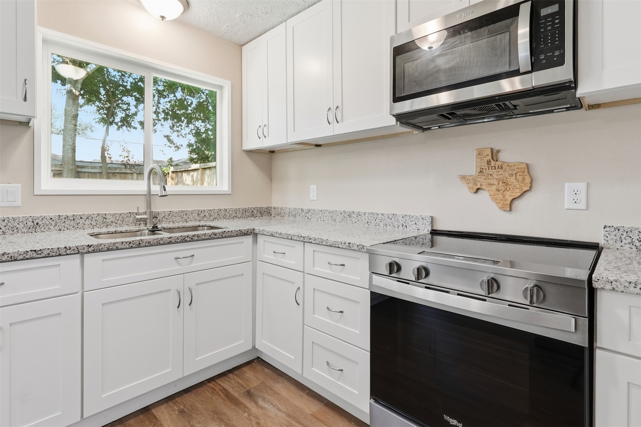 4767 Beechaven Street Houston, TX 77053 - Photo 10 of 26 a kitchen with granite countertop white cabinets white appliances and a window
